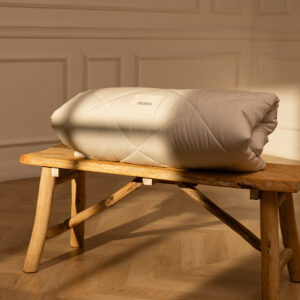 Couette de la marque Eraen 100% alapaga pliée sur un banc en bois
